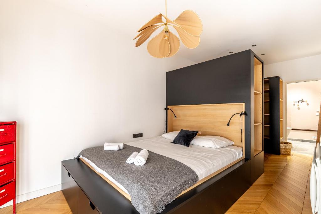 Bedroom 2 — dark headboard, pendant light, en-suite access